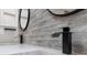 Modern bathroom featuring a double vanity with matte black faucets and wood-look tile backsplash at 2630 S Tanner Rd, Orlando, FL 32820
