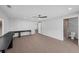 Bright living room with neutral tones, tile floors, ceiling fan, and adjacent bathroom at 2630 S Tanner Rd, Orlando, FL 32820