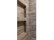 Shower features a custom niche for storage, and wood-look tile from floor to ceiling at 2630 S Tanner Rd, Orlando, FL 32820