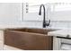 Close-up of a copper farmhouse sink with a matte black faucet and granite countertops at 2630 S Tanner Rd, Orlando, FL 32820