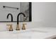 Modern bathroom sink featuring a unique black and gold faucet, reflecting in a sleek mirror at 2639 Monaco Cove Cir, Orlando, FL 32825