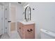 Bathroom with a pink vanity with an arched mirror and modern lighting at 2639 Monaco Cove Cir, Orlando, FL 32825
