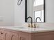 Chic bathroom vanity featuring a muted rose color, gold accents, a sleek countertop, and a modern faucet under a stylish mirror at 2639 Monaco Cove Cir, Orlando, FL 32825