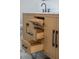 Stylish bathroom vanity with light wood finish, black hardware, offering convenient storage with multiple drawers and compartments at 2639 Monaco Cove Cir, Orlando, FL 32825