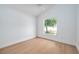 A bright bedroom featuring light wood flooring and a window that allows plenty of natural light at 2639 Monaco Cove Cir, Orlando, FL 32825