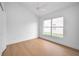 A bright bedroom featuring light wood flooring and a window that allows plenty of natural light at 2639 Monaco Cove Cir, Orlando, FL 32825