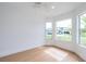 Bright bedroom featuring wood floors and three windows showcasing the neighborhood at 2639 Monaco Cove Cir, Orlando, FL 32825