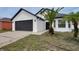 Charming single-story home featuring a 2-car garage, dark trim, and mature palm trees at 2639 Monaco Cove Cir, Orlando, FL 32825
