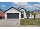 Beautiful home featuring a dark garage door, well-manicured lawn, and healthy palm trees for added curb appeal at 2639 Monaco Cove Cir, Orlando, FL 32825