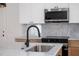 Kitchen island featuring marble countertop, modern black faucet, and stainless steel appliances in the background at 2639 Monaco Cove Cir, Orlando, FL 32825