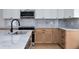 The kitchen has marble counter tops, with stainless steel appliances, and blonde wood cabinets at 2639 Monaco Cove Cir, Orlando, FL 32825