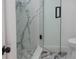 Modern glass shower door shows mosaic flooring and a marble tiled shower at 2639 Monaco Cove Cir, Orlando, FL 32825