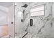 Modern shower featuring stylish marble tiling, glass door and black hardware at 2639 Monaco Cove Cir, Orlando, FL 32825