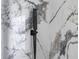 Close up of a matte black shower head against patterned marble tiling at 2639 Monaco Cove Cir, Orlando, FL 32825