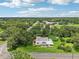 An aerial view shows a cozy home surrounded by a canopy of lush trees at 302 E Oakland Ave, Oakland, FL 34760