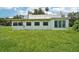 Back exterior of a single-story home surrounded by a large grassy yard at 302 E Oakland Ave, Oakland, FL 34760