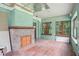 Spacious living room with original fireplace, hardwood floors, and natural light from large windows at 302 E Oakland Ave, Oakland, FL 34760
