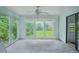 Bright sunroom featuring large windows offering views of the lush, green backyard at 302 E Oakland Ave, Oakland, FL 34760