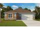 Charming single-story home with stone accents, light blue siding, and a well-manicured lawn at 33644 Seattle Slew Dr, Sorrento, FL 32776