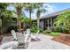 Private backyard features a brick paver patio, white adirondack chairs, and lush landscaping at 3601 S Summerlin Ave, Orlando, FL 32806