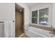 Bright bathroom with tub, shower, tile surround and a window offering natural light at 3601 S Summerlin Ave, Orlando, FL 32806