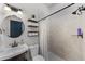 Updated bathroom features a tiled shower, vanity with dark wood cabinets and round mirror at 3601 S Summerlin Ave, Orlando, FL 32806