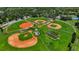 Aerial view of a baseball park with multiple fields, batting cages, and well-maintained green spaces at 410 Winter Bliss Ln, Mount Dora, FL 32757