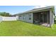 The backyard is mostly green with an enclosed patio, white fencing and a gray stucco home at 410 Winter Bliss Ln, Mount Dora, FL 32757