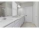 Bright bathroom featuring double sinks, white cabinets, and a large mirror at 410 Winter Bliss Ln, Mount Dora, FL 32757
