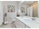 Neutral bathroom with double sinks, white cabinets, large mirror, tub and shower combo at 410 Winter Bliss Ln, Mount Dora, FL 32757