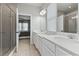 Bright primary bathroom featuring double sinks, white cabinets, and glass shower door at 410 Winter Bliss Ln, Mount Dora, FL 32757