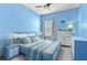 Cozy blue bedroom with fan, window, two dressers, and comfortable bed at 410 Winter Bliss Ln, Mount Dora, FL 32757