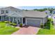Charming one-story home with a brick driveway, gray exterior, and well-manicured landscaping at 410 Winter Bliss Ln, Mount Dora, FL 32757