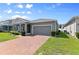 Well-maintained home with brick driveway, gray exterior, and neat landscaping for curb appeal at 410 Winter Bliss Ln, Mount Dora, FL 32757