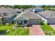 Charming one-story home featuring a covered porch with seating and a brick paver driveway at 410 Winter Bliss Ln, Mount Dora, FL 32757