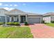 Charming single-story home with a brick driveway, covered porch, and a two-car garage at 410 Winter Bliss Ln, Mount Dora, FL 32757