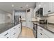Bright kitchen boasts white cabinets, stainless steel appliances, and granite countertops at 410 Winter Bliss Ln, Mount Dora, FL 32757