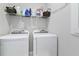 Functional laundry room with washer, dryer, and wire rack shelving for storage at 410 Winter Bliss Ln, Mount Dora, FL 32757