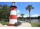 A picturesque red and white lighthouse on a sunny day with palm trees and bench seating at 410 Winter Bliss Ln, Mount Dora, FL 32757