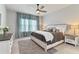 Serene main bedroom with a king-sized bed, soft lighting, and a relaxing atmosphere enhanced by the curtains at 410 Winter Bliss Ln, Mount Dora, FL 32757