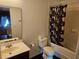 Standard bathroom with a toilet, sink, mirror and a shower/tub with a patterned curtain at 438 Janice Kay Pl, Kissimmee, FL 34744