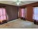 Empty bedroom with dark brown walls, carpet flooring and several windows dressed with curtains at 438 Janice Kay Pl, Kissimmee, FL 34744