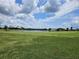 Beautiful view of the golf course with a lake and lush green grass under a blue sky at 438 Janice Kay Pl, Kissimmee, FL 34744
