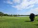 Scenic view of the golf course with a lake, lush green grass and blue sky at 438 Janice Kay Pl, Kissimmee, FL 34744