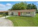 Charming single-story home with a well-maintained lawn and a bright red front door for added curb appeal at 4825 Loretta Ln, Orlando, FL 32821