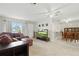 Cozy living room with tile floors and a comfortable L-shaped couch with a view into the dining room at 4825 Loretta Ln, Orlando, FL 32821