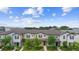 A high angle showing multiple two-story townhomes with lush landscaping against a blue sky with scattered clouds at 5030 Caspian St, St Cloud, FL 34771