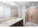 Bathroom with double sinks, granite counters, a large mirror and a walk-in shower at 5030 Caspian St, St Cloud, FL 34771