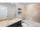 Bathroom featuring granite countertops, a bathtub with tiled walls and a shower head, and shelves at 5030 Caspian St, St Cloud, FL 34771