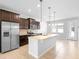 A spacious kitchen with stainless appliances, dark wood cabinets, granite counters, and modern pendant lights at 5030 Caspian St, St Cloud, FL 34771